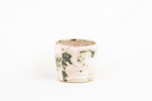 White glaze featuring splashed oxide mug with pink and green hues